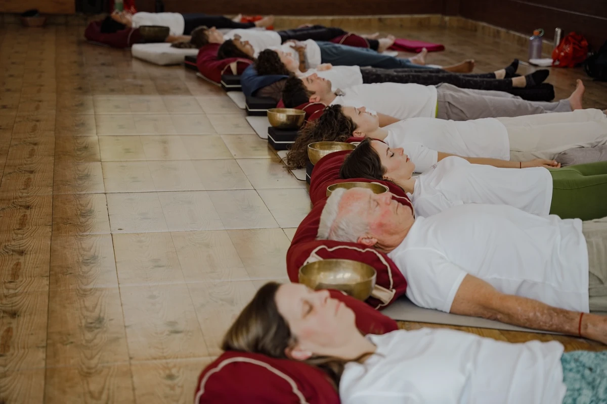 Participants practicing Tibetan singing bowl therapy during Adhiroha’s TTC
