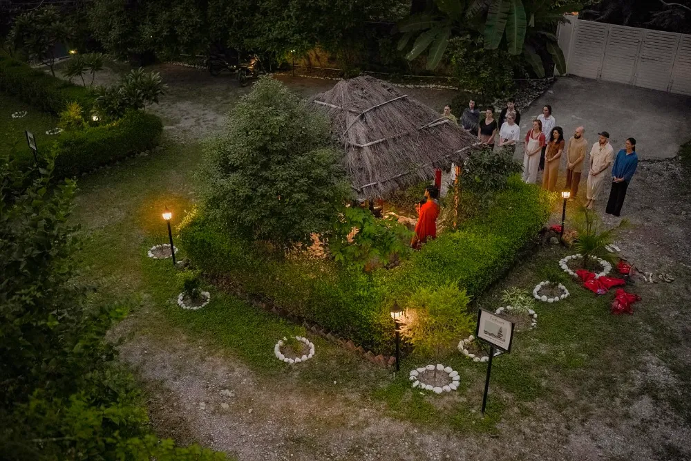 Students gathered for the evening lamp ceremony in the ashram garden at dusk