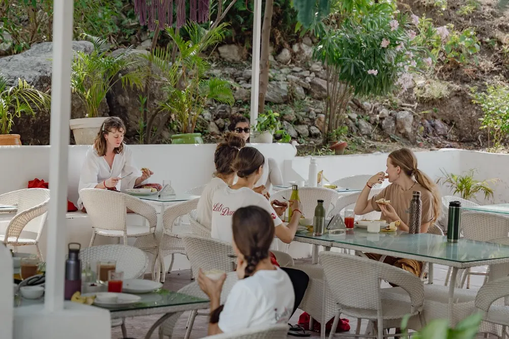 Students sharing a meal in the open-air dining space at Adhiroha