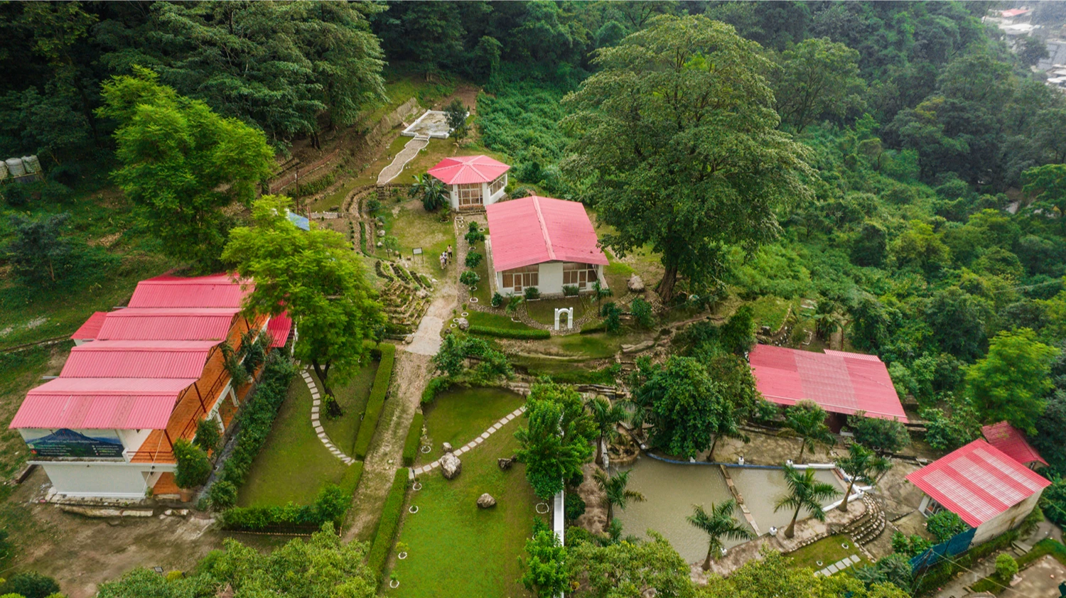 The full Adhiroha ashram campus from above, set among the green hills of Upper Tapovan