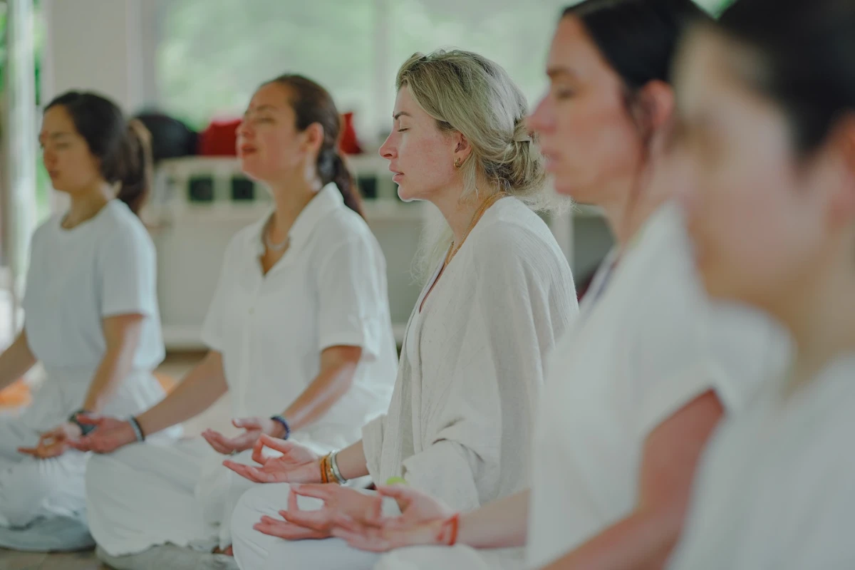A teacher guiding a student through a Hatha posture on the Hatha and Yin course