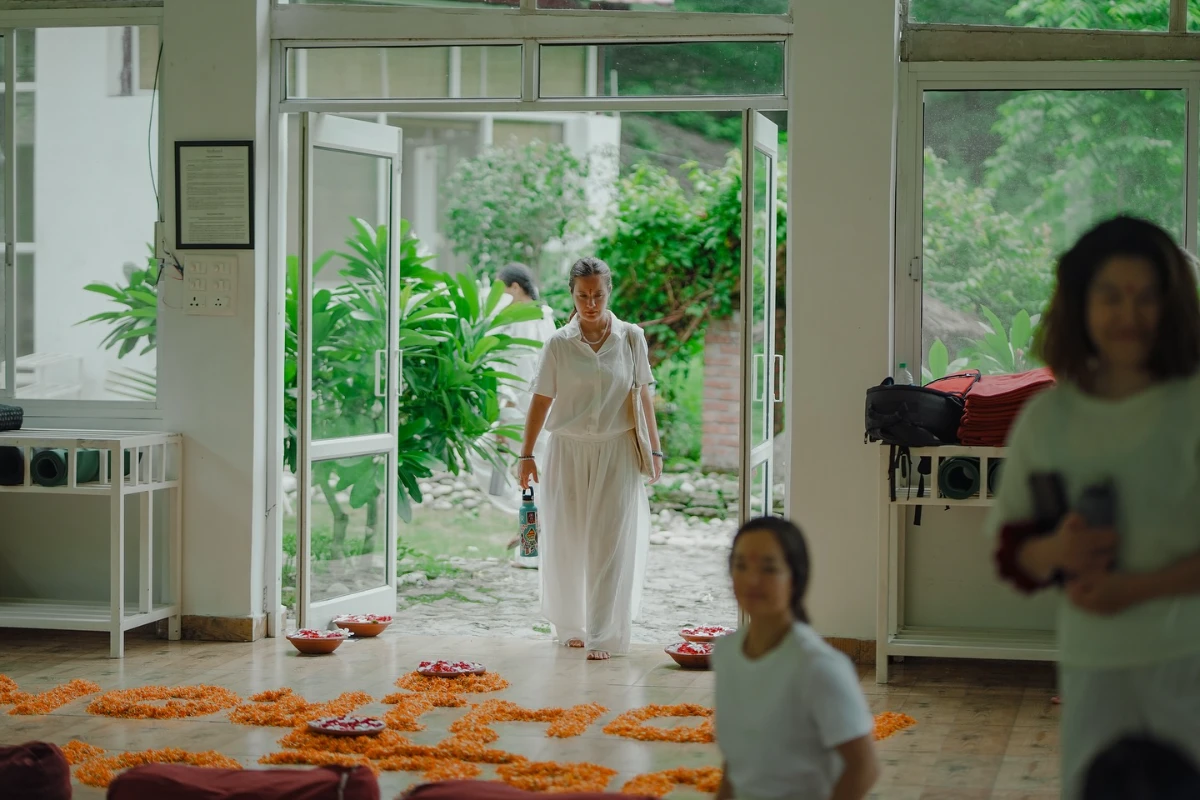 A student in a sunlit room during a morning ritual at the ashram