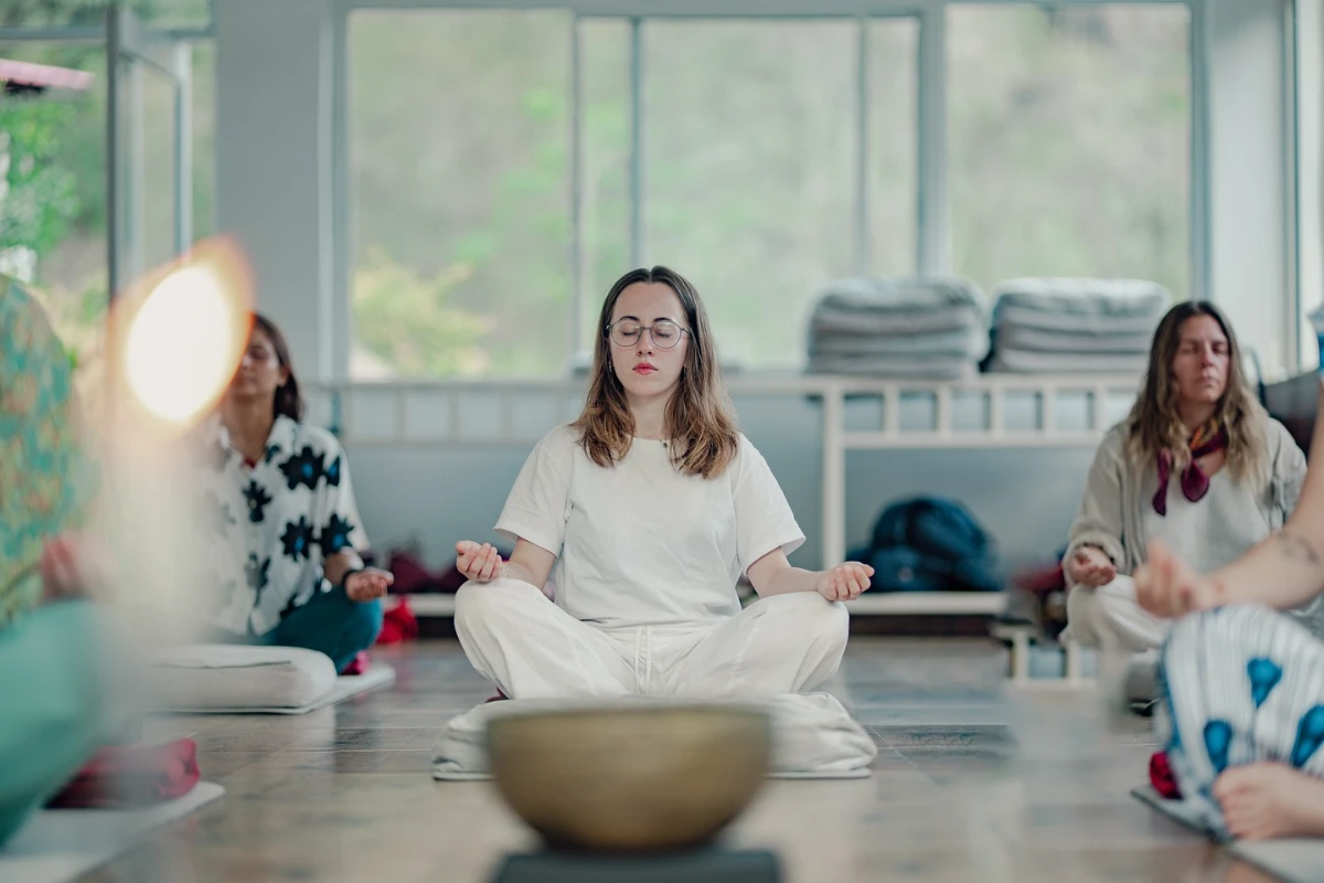 Students meditating around singing bowls in a sound healing session