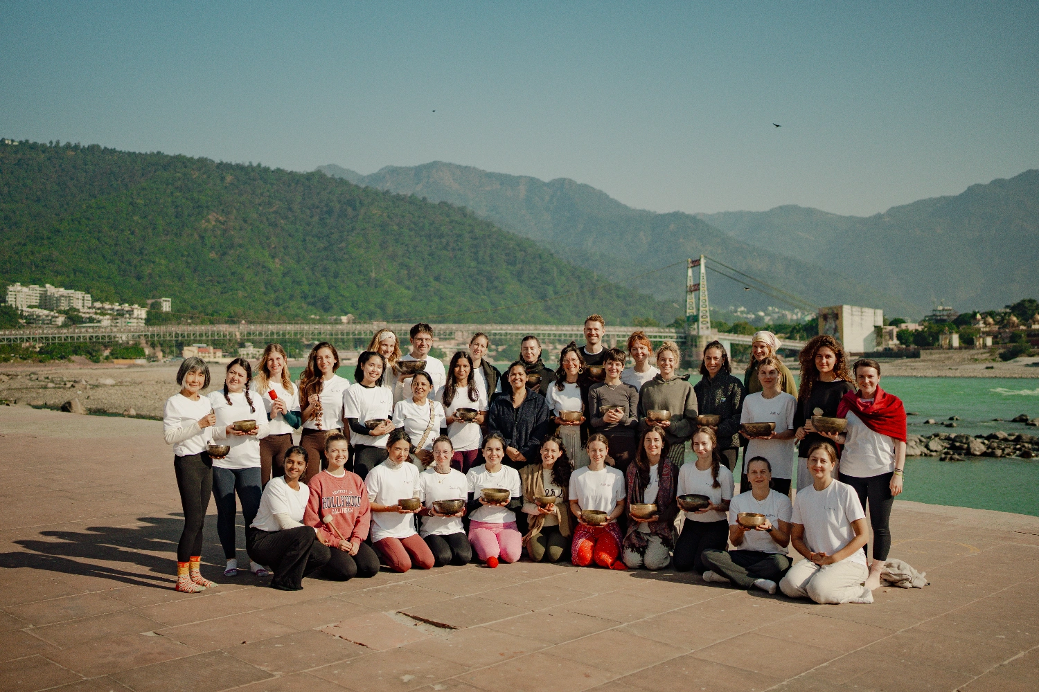 Eine Gruppen-Klangheilungs-Session am Ganga Ji, dahinter das Himalaya-Vorgebirge
