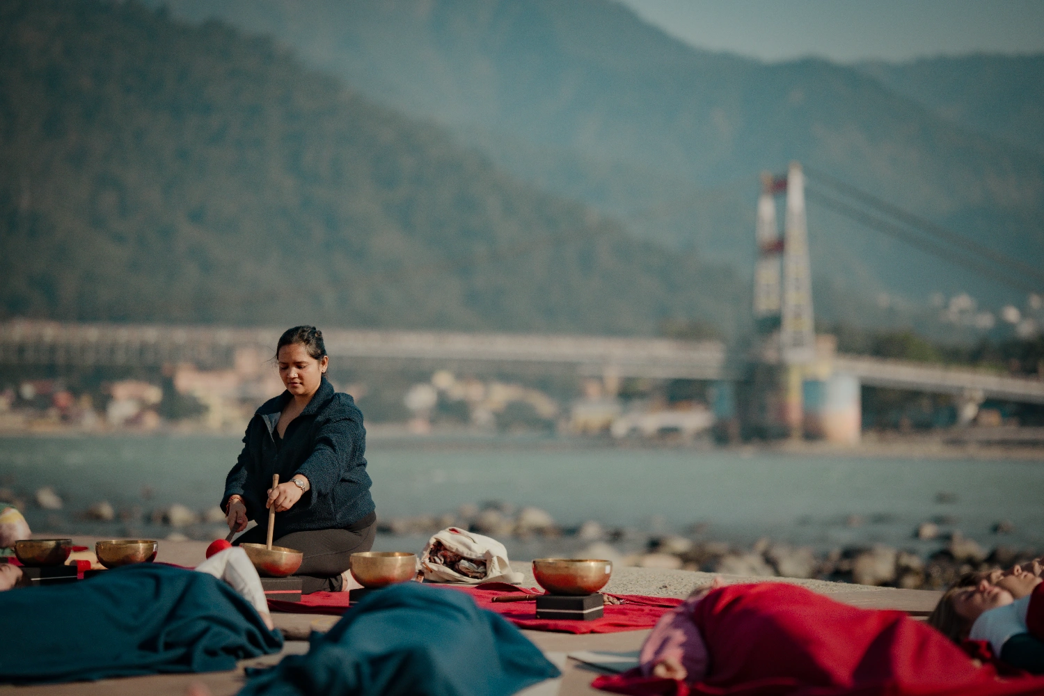Eine Klangheilungs-Session am Ganga-Ji-Ghat, in der Ferne die Laxman Jhula