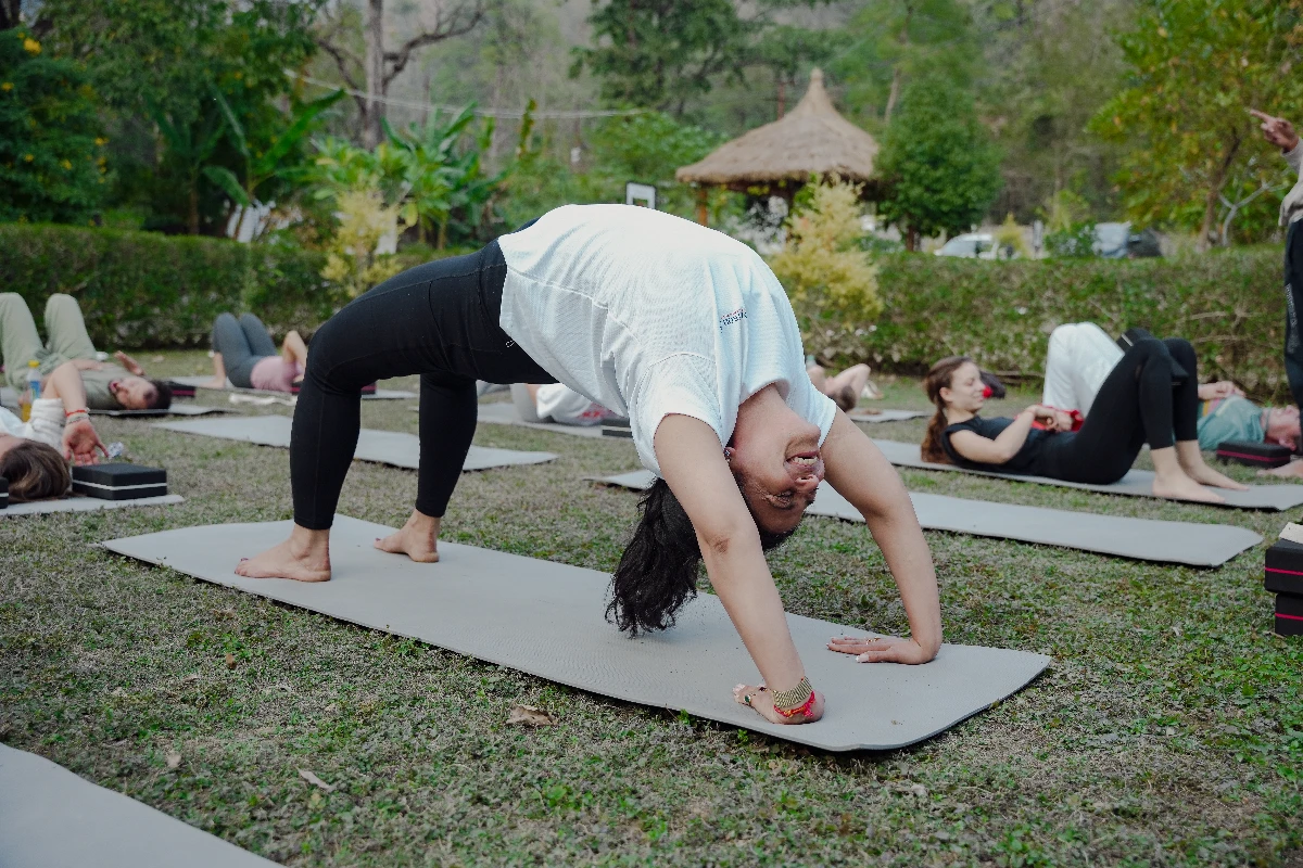 Woman practicing gentle evening yoga in comfortable sleepwear on mat in softly lit bedroom with calming atmosphere